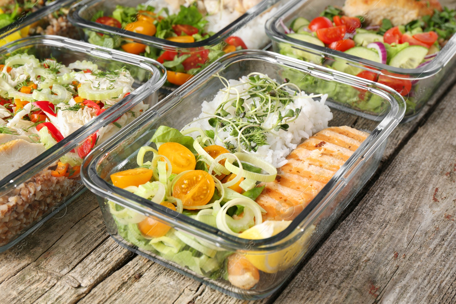 Photo of Healthy meal. Containers with different products on wooden table, closeup