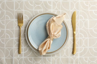 Photo of Stylish setting with cutlery, plates and napkin on table, top view