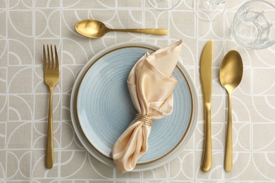 Stylish setting with cutlery, plates, napkin and glass on table, flat lay