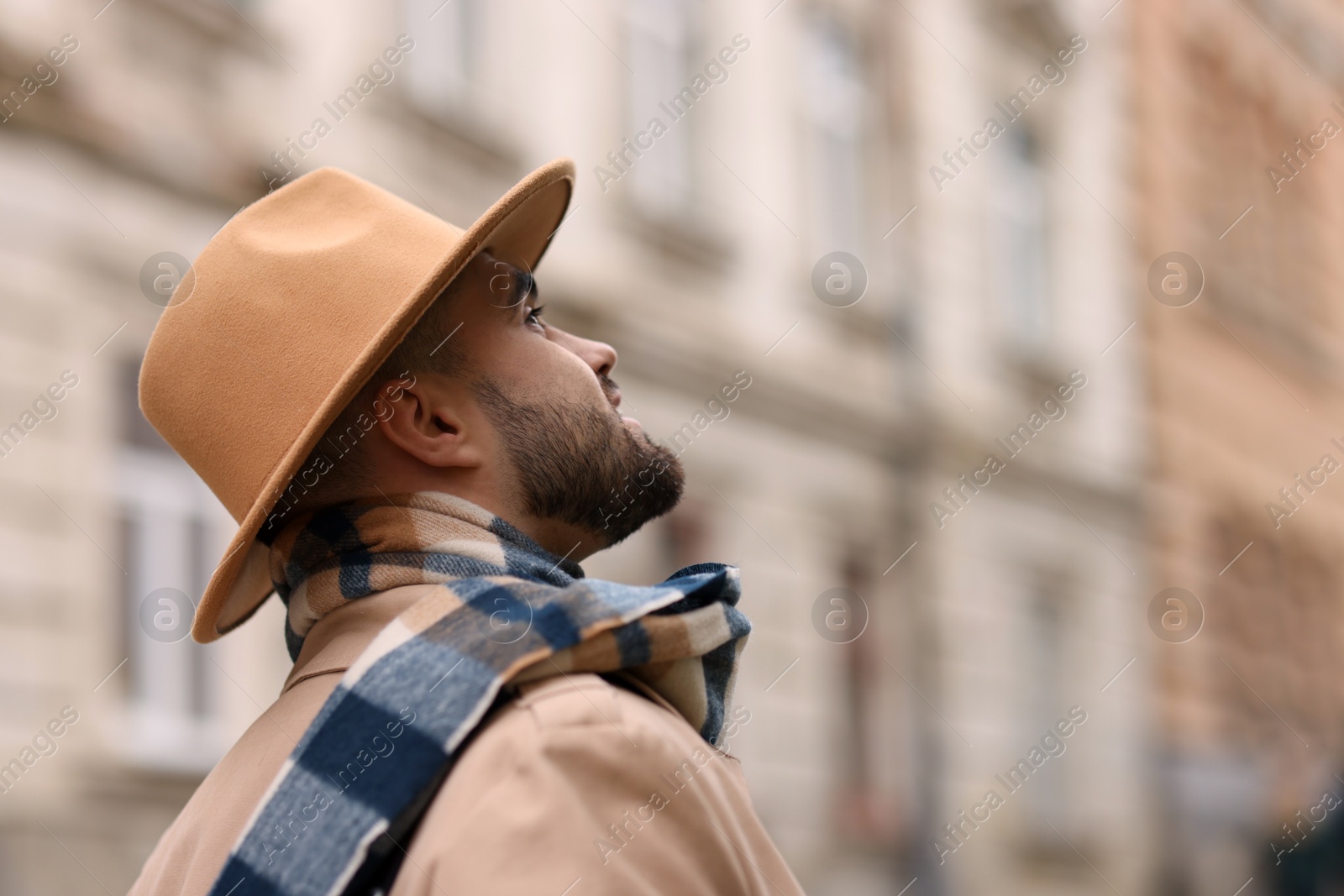 Photo of Man in warm scarf on blurred background. Space for text