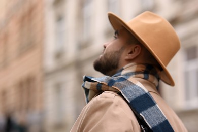 Photo of Man in warm scarf on blurred background. Space for text