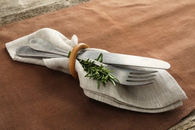 Stylish setting with cutlery and napkin on table, closeup