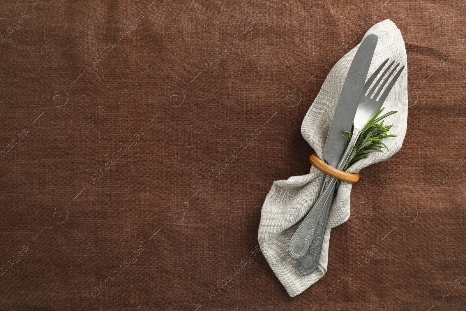 Photo of Stylish setting with cutlery and napkin on table, top view. Space for text