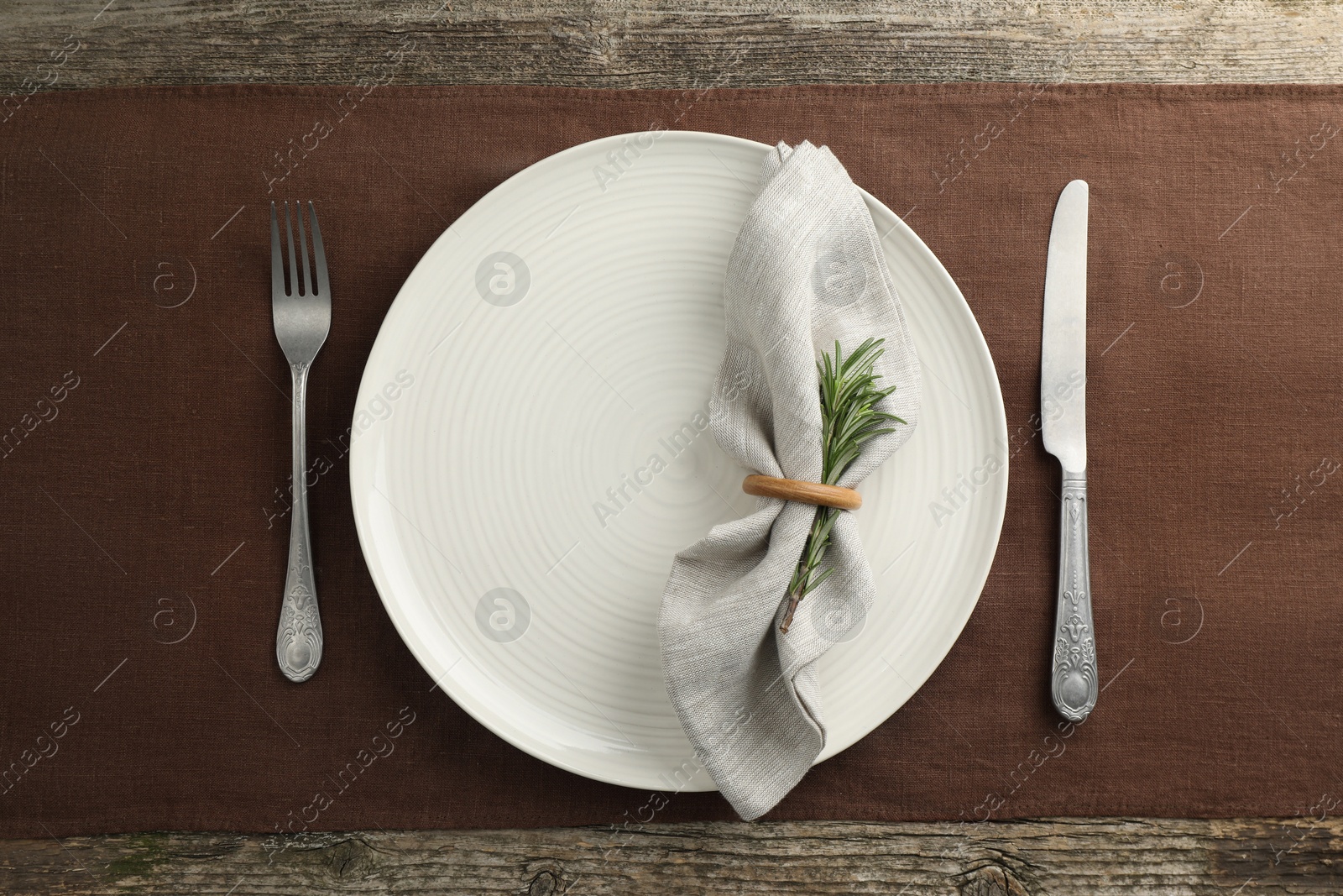 Photo of Stylish setting with cutlery and plate on wooden table, flat lay