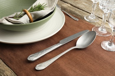 Photo of Stylish setting with cutlery, glasses, plate and bowl on wooden table, closeup