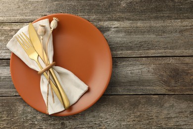 Stylish setting with cutlery and plate on wooden table, top view. Space for text