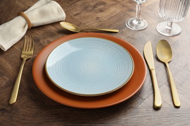 Photo of Stylish setting with cutlery, glasses and plates on wooden table