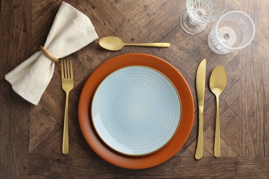 Photo of Stylish setting with cutlery, glasses and plates on wooden table, flat lay