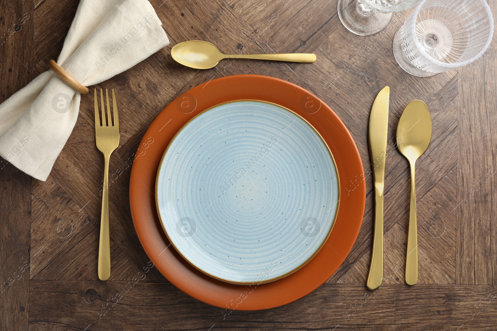 Photo of Stylish setting with cutlery, glasses and plates on wooden table, flat lay