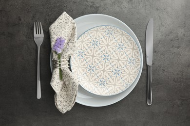 Photo of Stylish setting with cutlery and plates on black table, flat lay