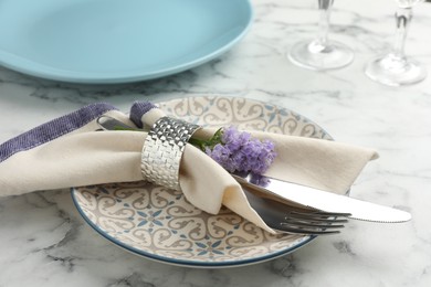Photo of Stylish setting with cutlery and plates on white marble table