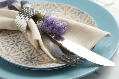 Photo of Stylish setting with cutlery and plates on white marble table, closeup