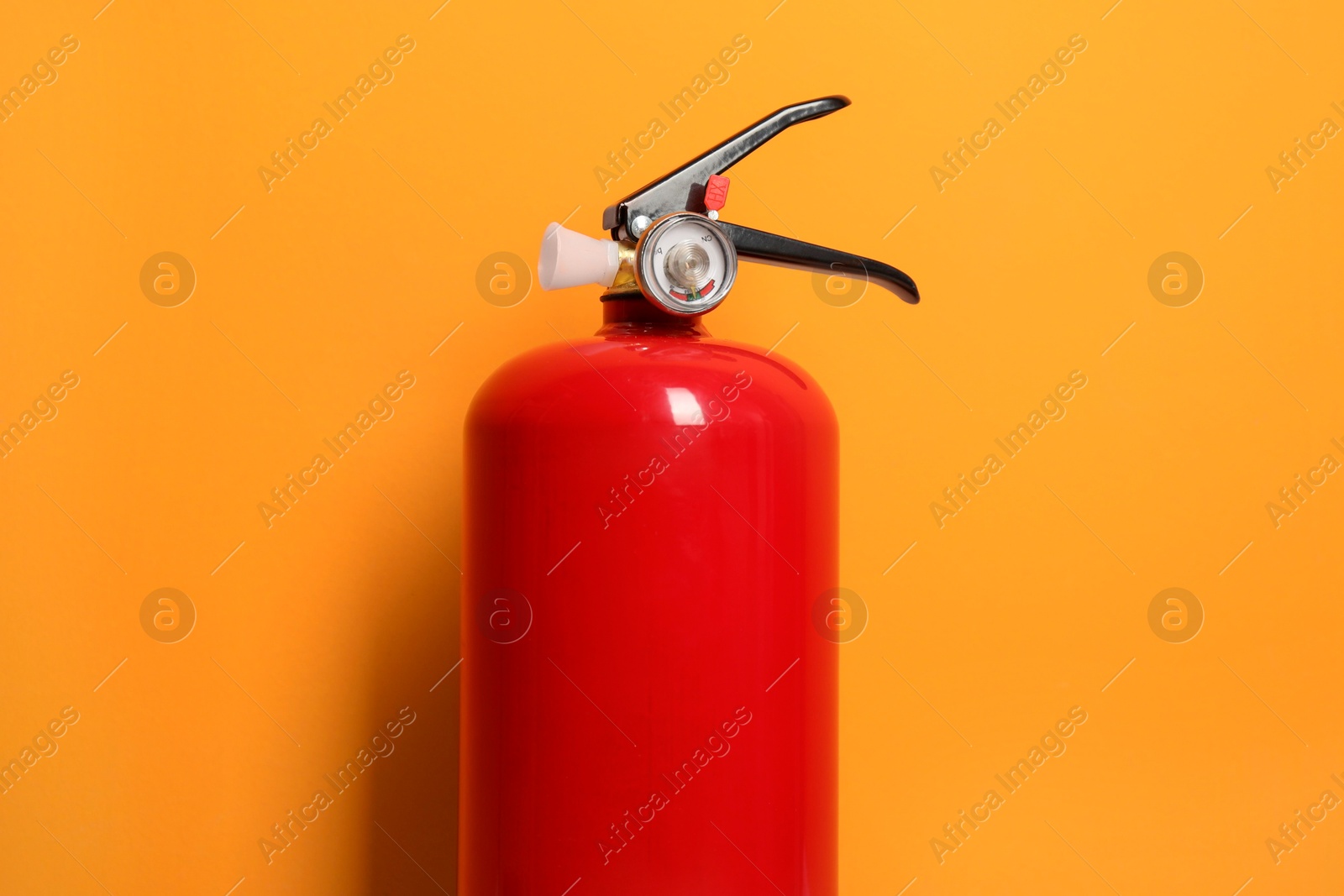 Photo of One fire extinguisher on bright orange background