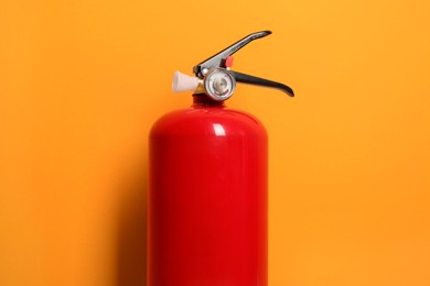 Photo of One fire extinguisher on bright orange background