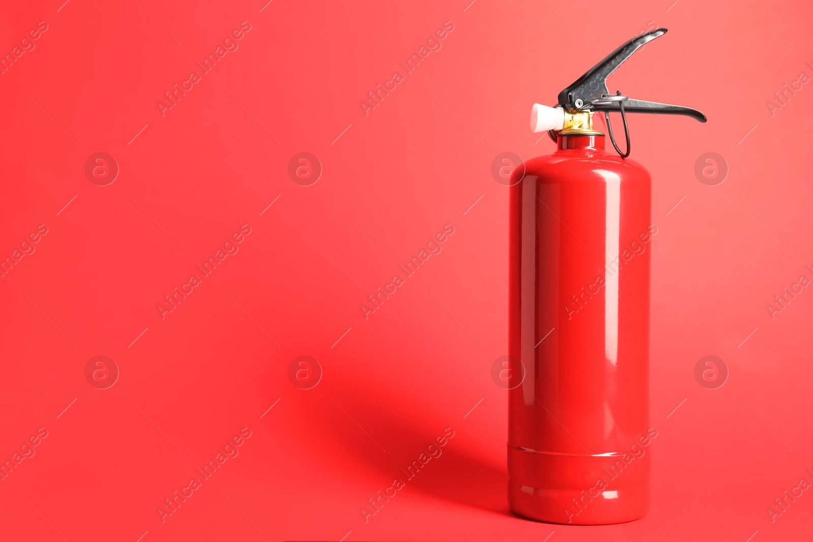 Photo of One fire extinguisher on red background, space for text