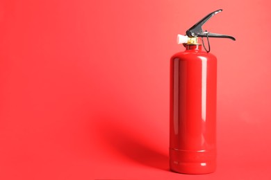 Photo of One fire extinguisher on red background, space for text