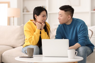 Happy couple spending time together and using laptop at home