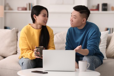 Happy couple spending time together and using laptop at home