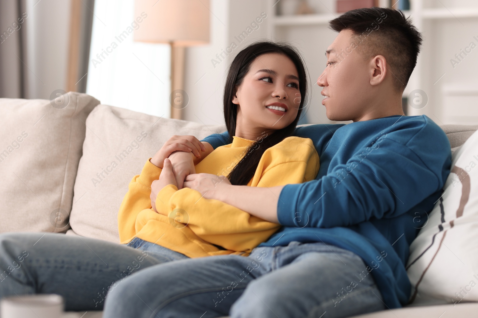 Photo of Happy young couple on sofa at home