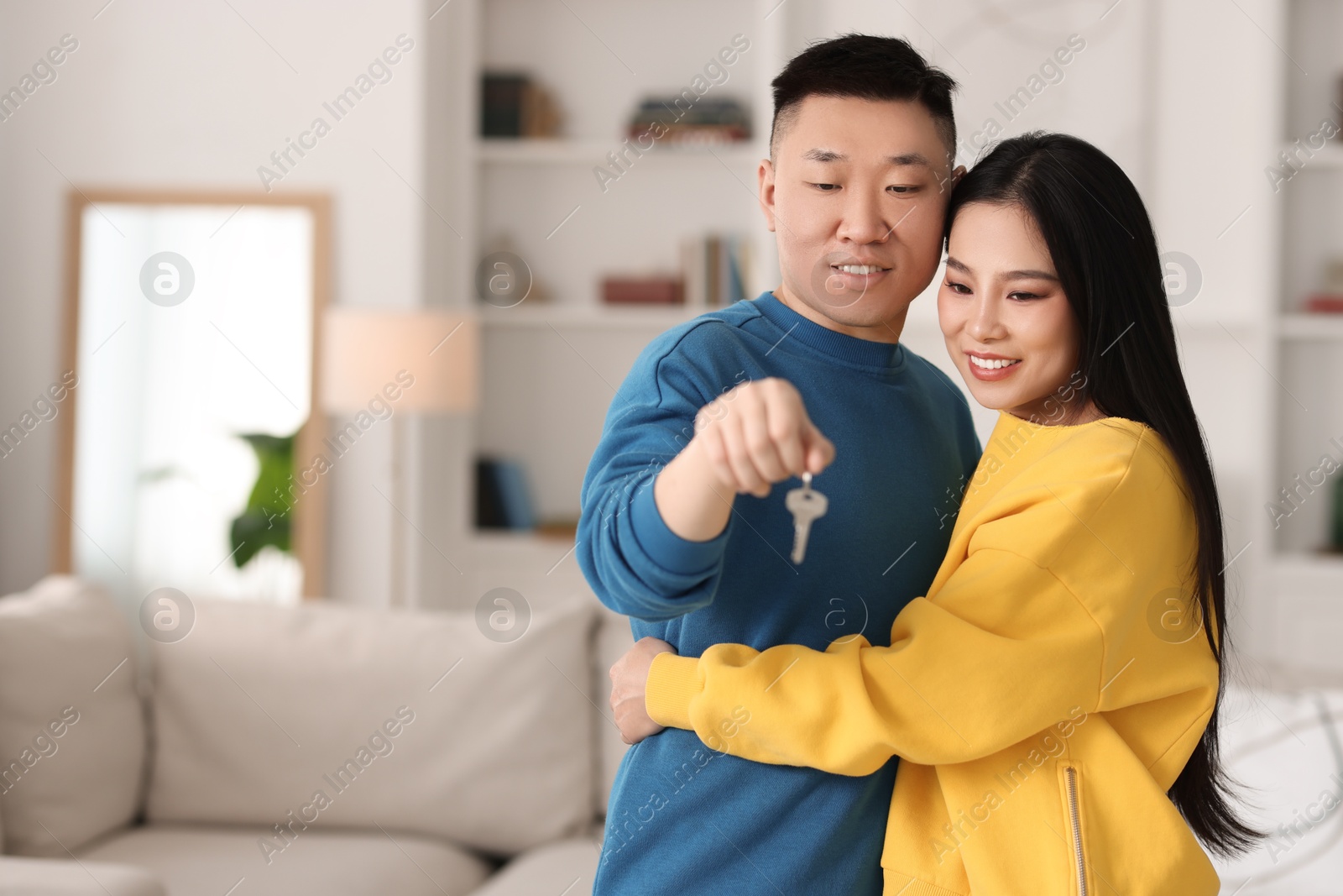 Photo of Happy couple with key in their new apartment, space for text