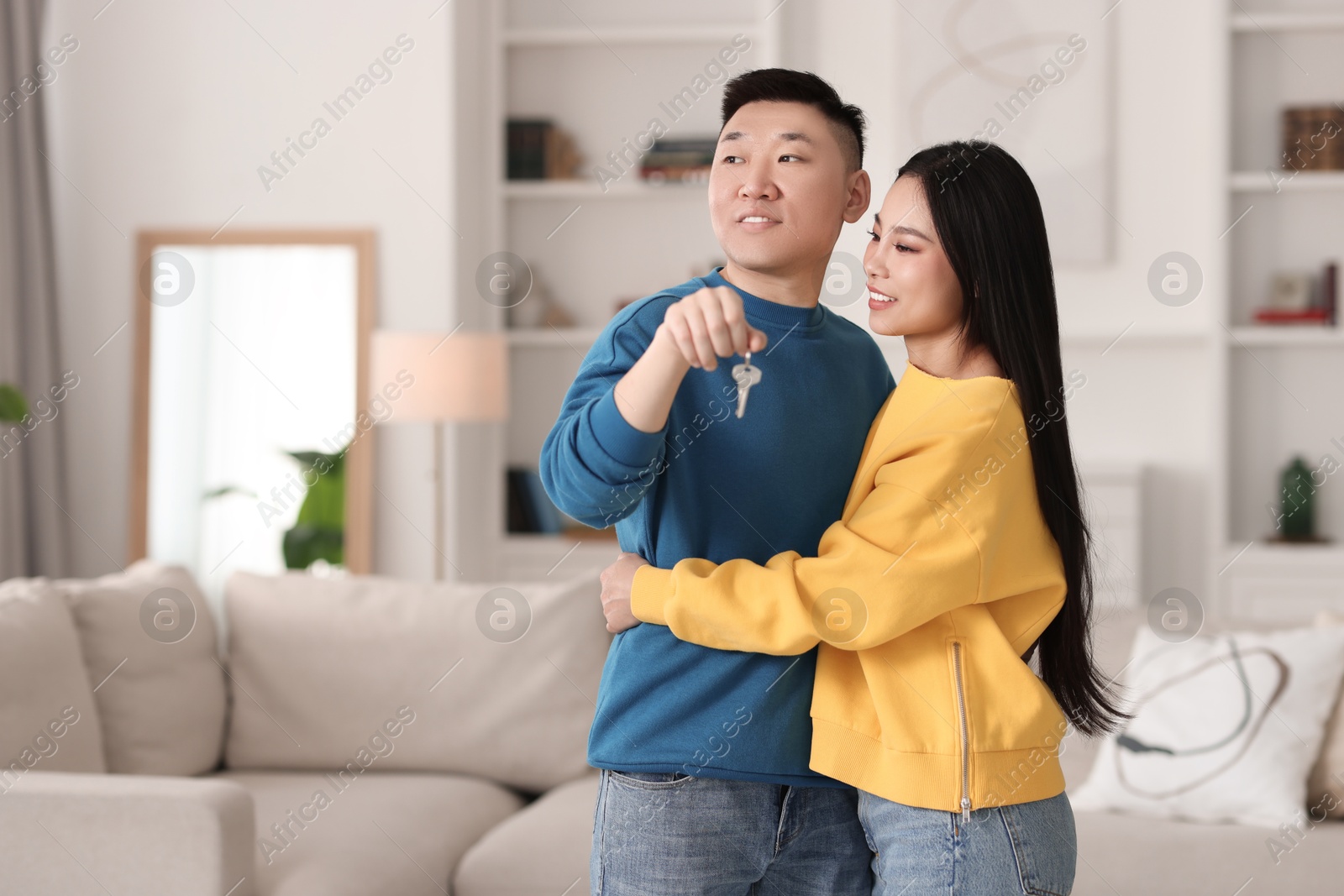 Photo of Happy couple with key in their new apartment, space for text