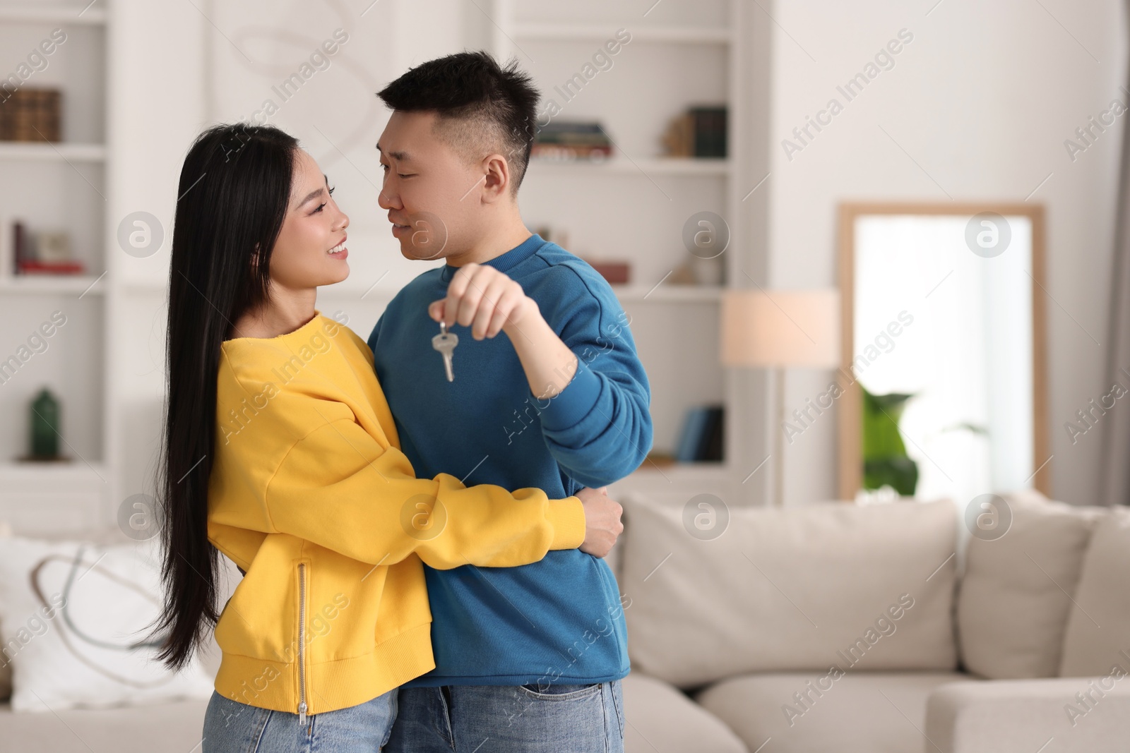 Photo of Happy couple with key in their new apartment, space for text