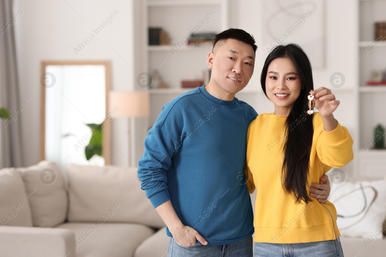 Photo of Happy couple with key in their new apartment, space for text