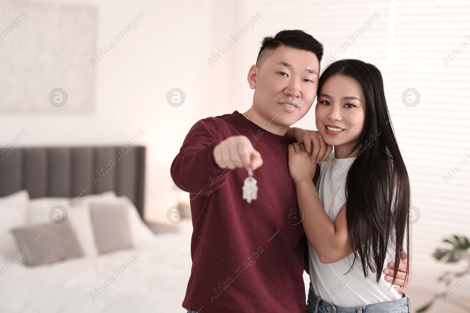 Photo of Happy couple with key in their new apartment, space for text