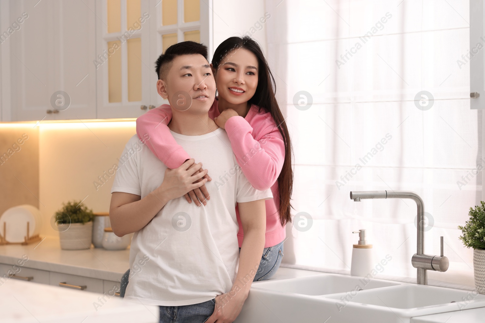 Photo of Portrait of lovely young couple in kitchen