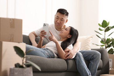 Photo of Happy couple with smartphone in their new apartment