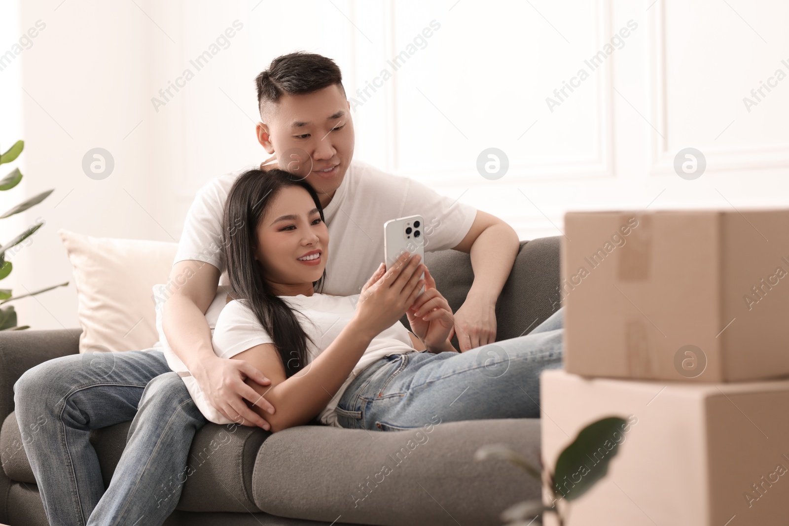 Photo of Happy couple with smartphone in their new apartment