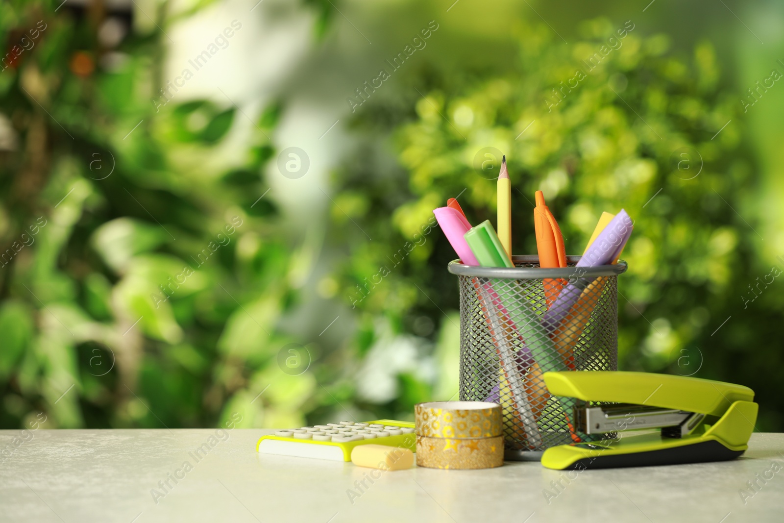 Photo of Stapler, holder and other different stationery on white table, space for text