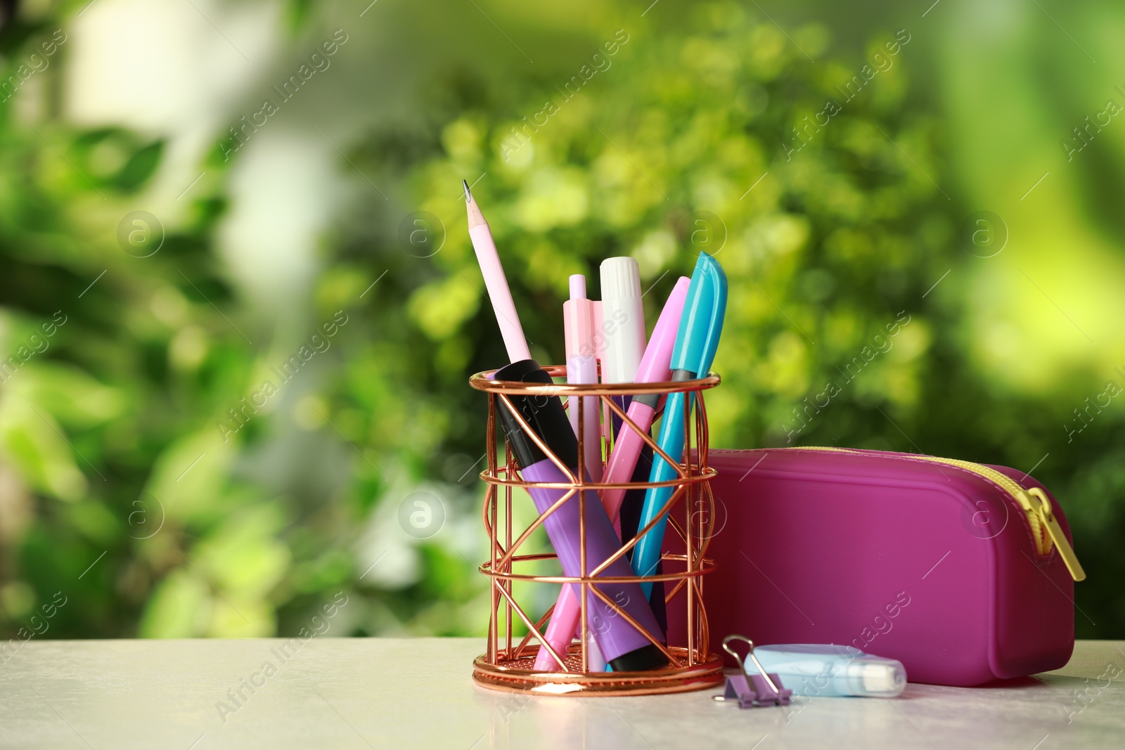 Photo of Holder, pencil case and other different stationery on white table, space for text