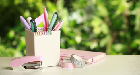 Photo of Stapler, holder and other different stationery on white table, space for text