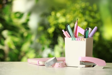 Photo of Stapler, holder and other different stationery on white table, space for text