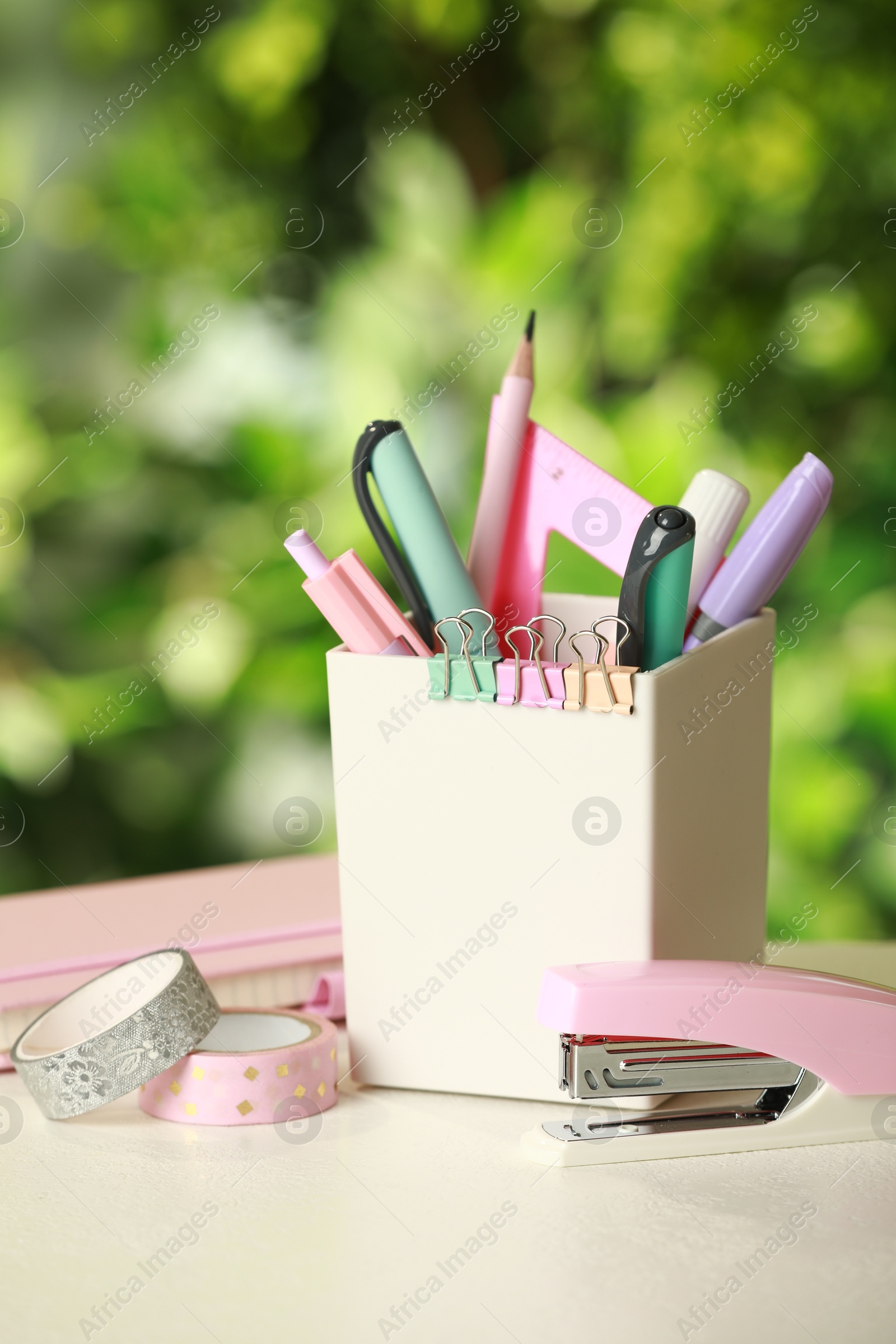 Photo of Stapler, holder and other different stationery on white table