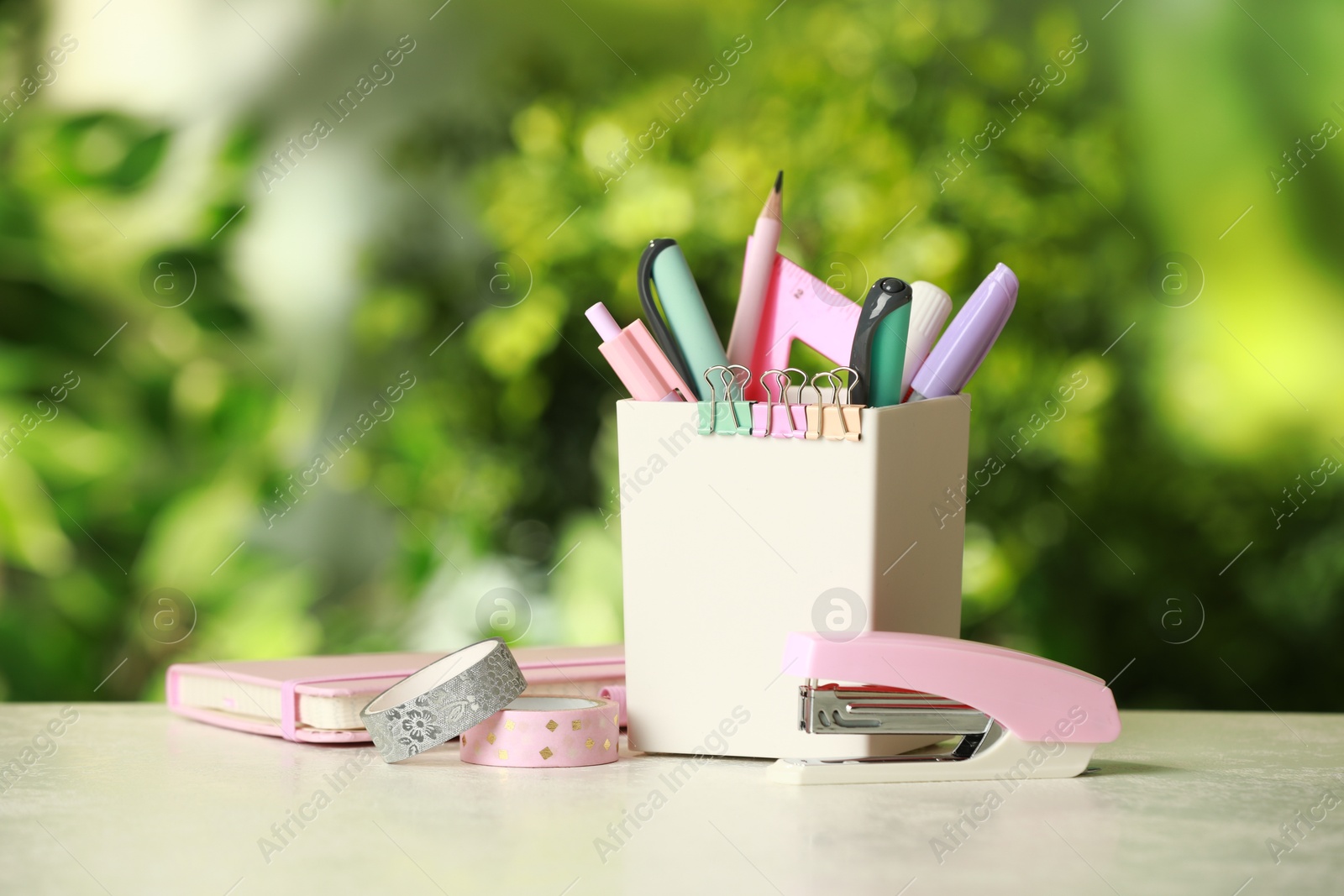 Photo of Stapler, holder and other different stationery on white table