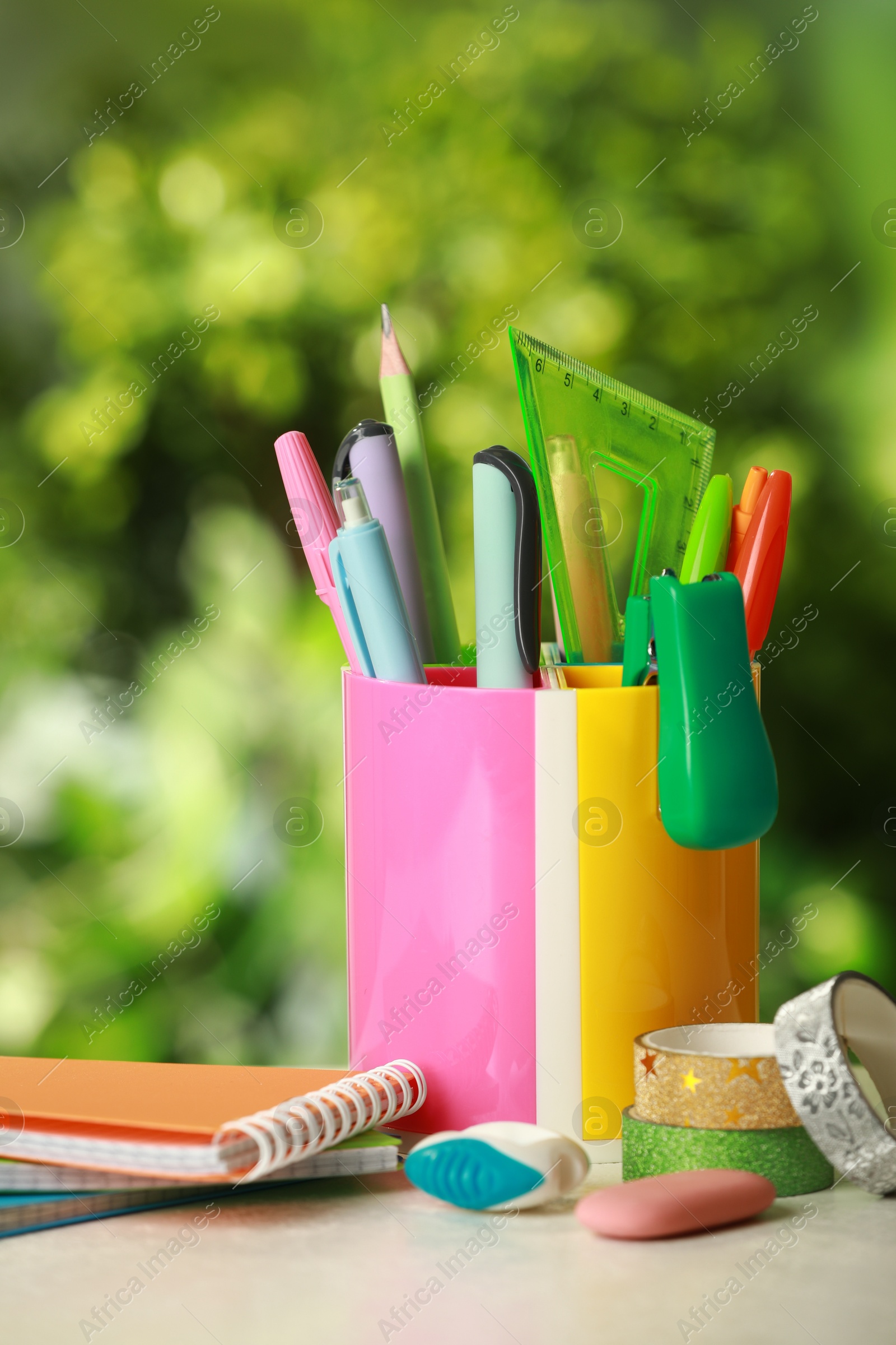 Photo of Stapler, notebooks, holder and other different stationery on white table