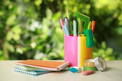 Photo of Stapler, notebooks, holder and other different stationery on white table