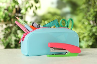 Stapler, pencil case and other different stationery on white table