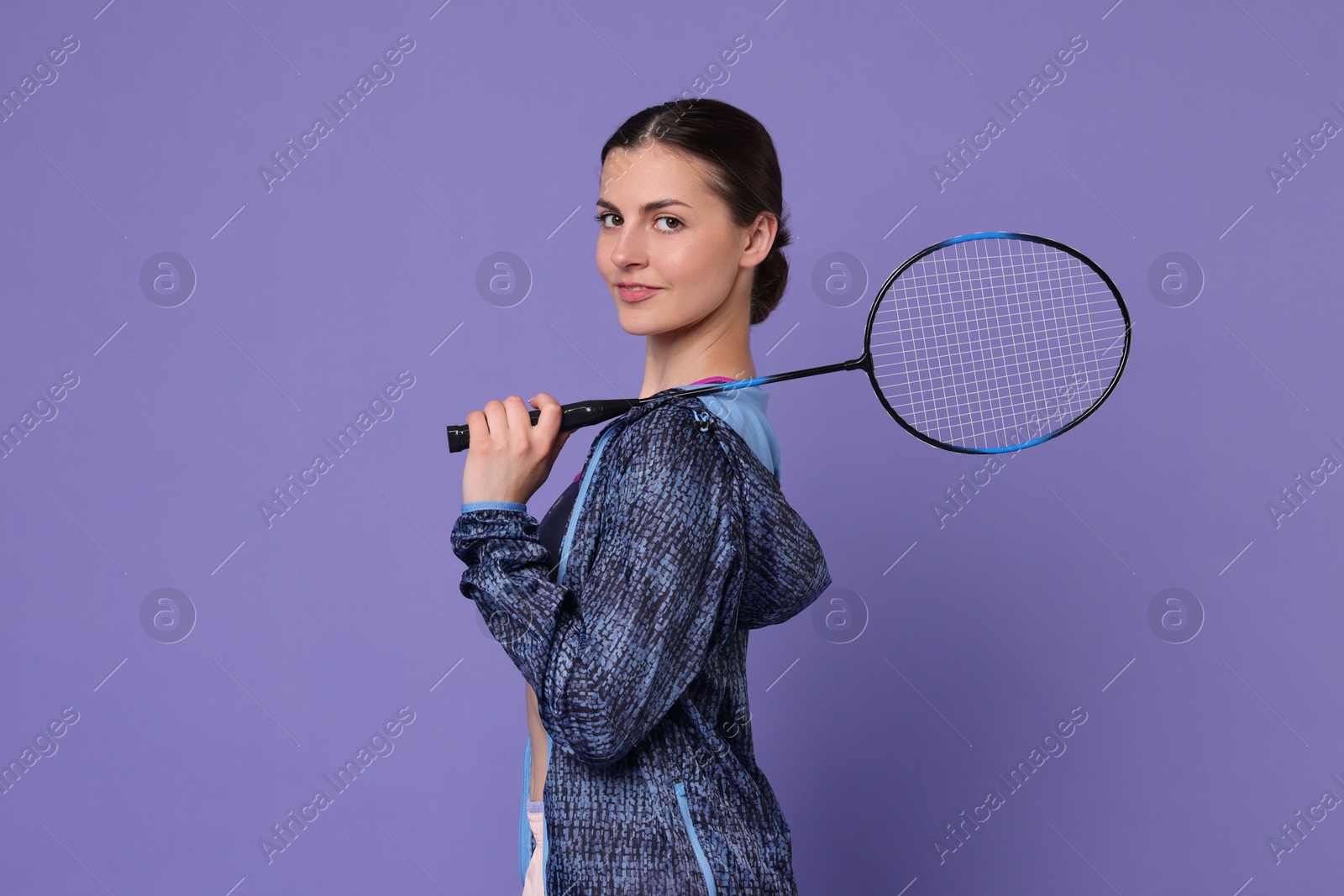 Photo of Young woman with badminton racket on purple background