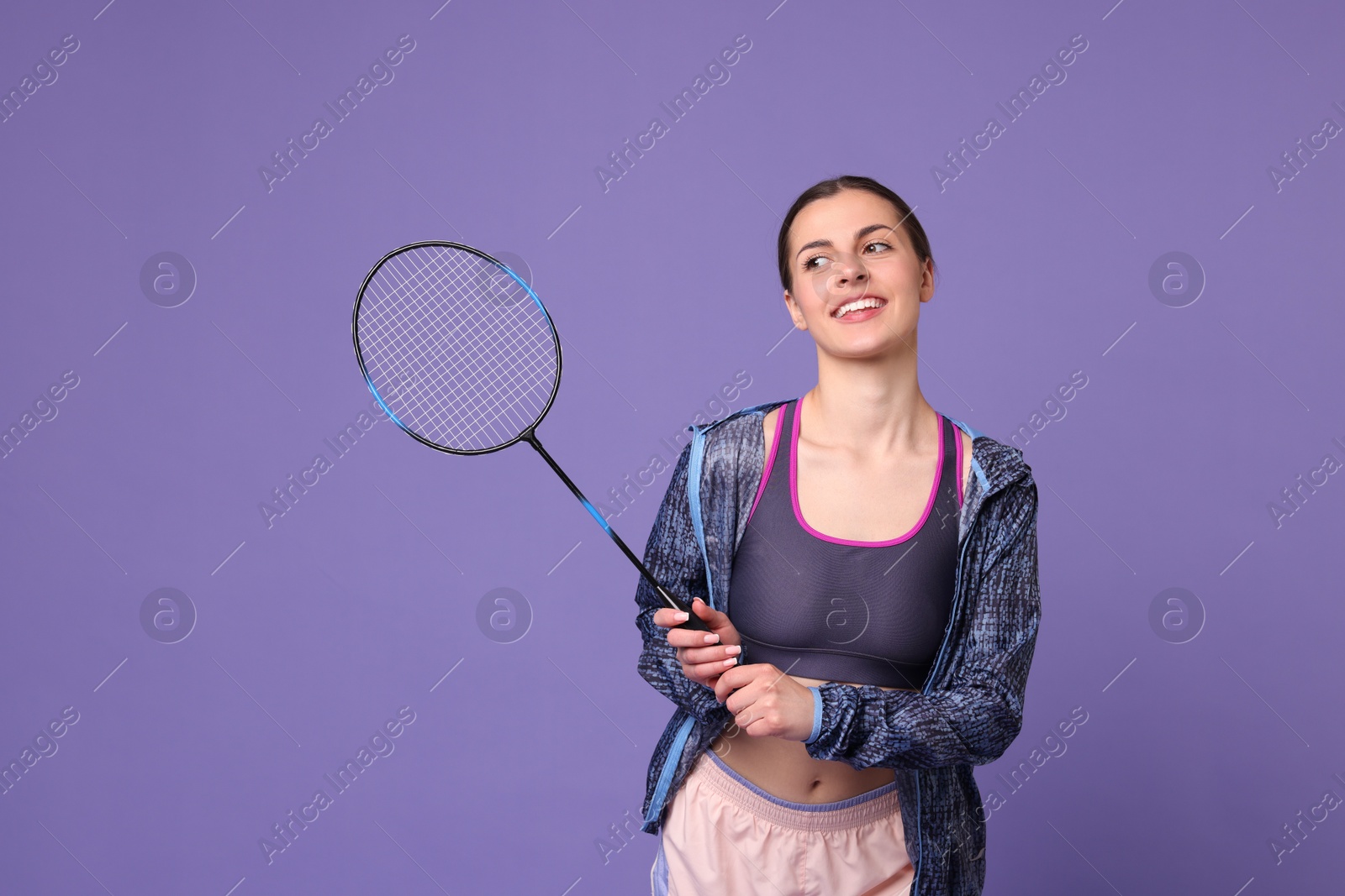 Photo of Young woman with badminton racket on purple background