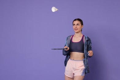Young woman with badminton racket and shuttlecock on purple background, space for text