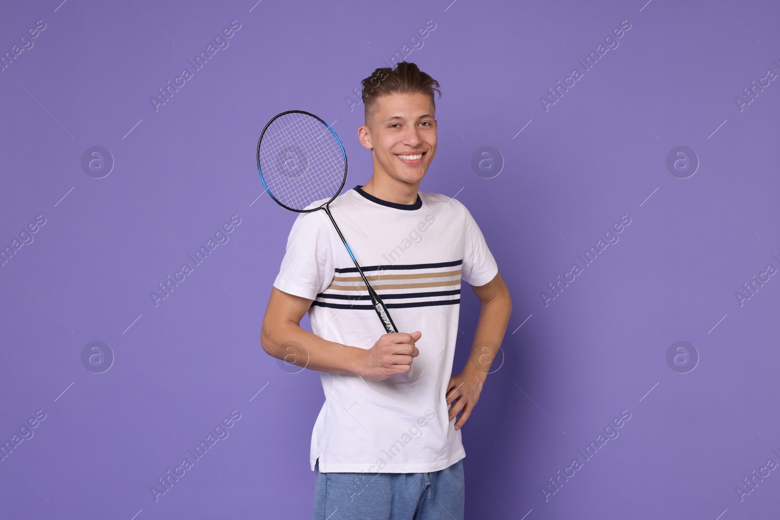 Photo of Young man with badminton racket on purple background