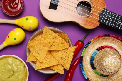 Photo of Flat lay composition with nachos chips and Mexican sombrero hat on purple background