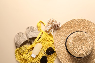 Photo of String bag and different beach accessories on beige background, top view. Space for text