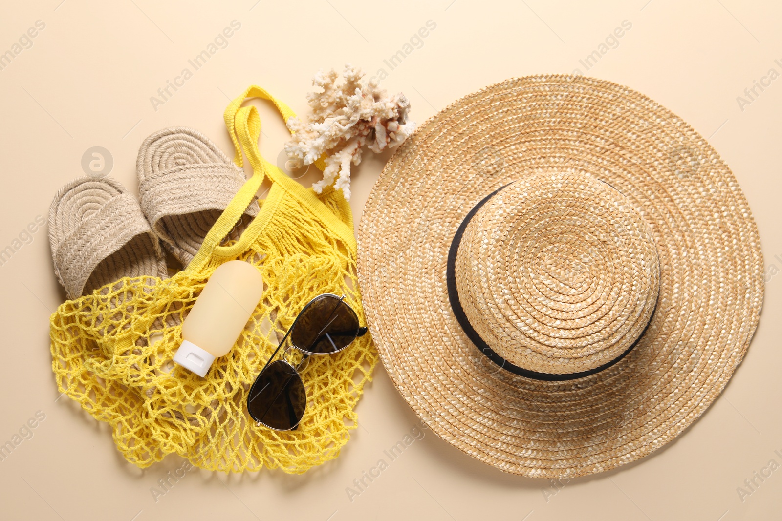 Photo of String bag and different beach accessories on beige background, top view