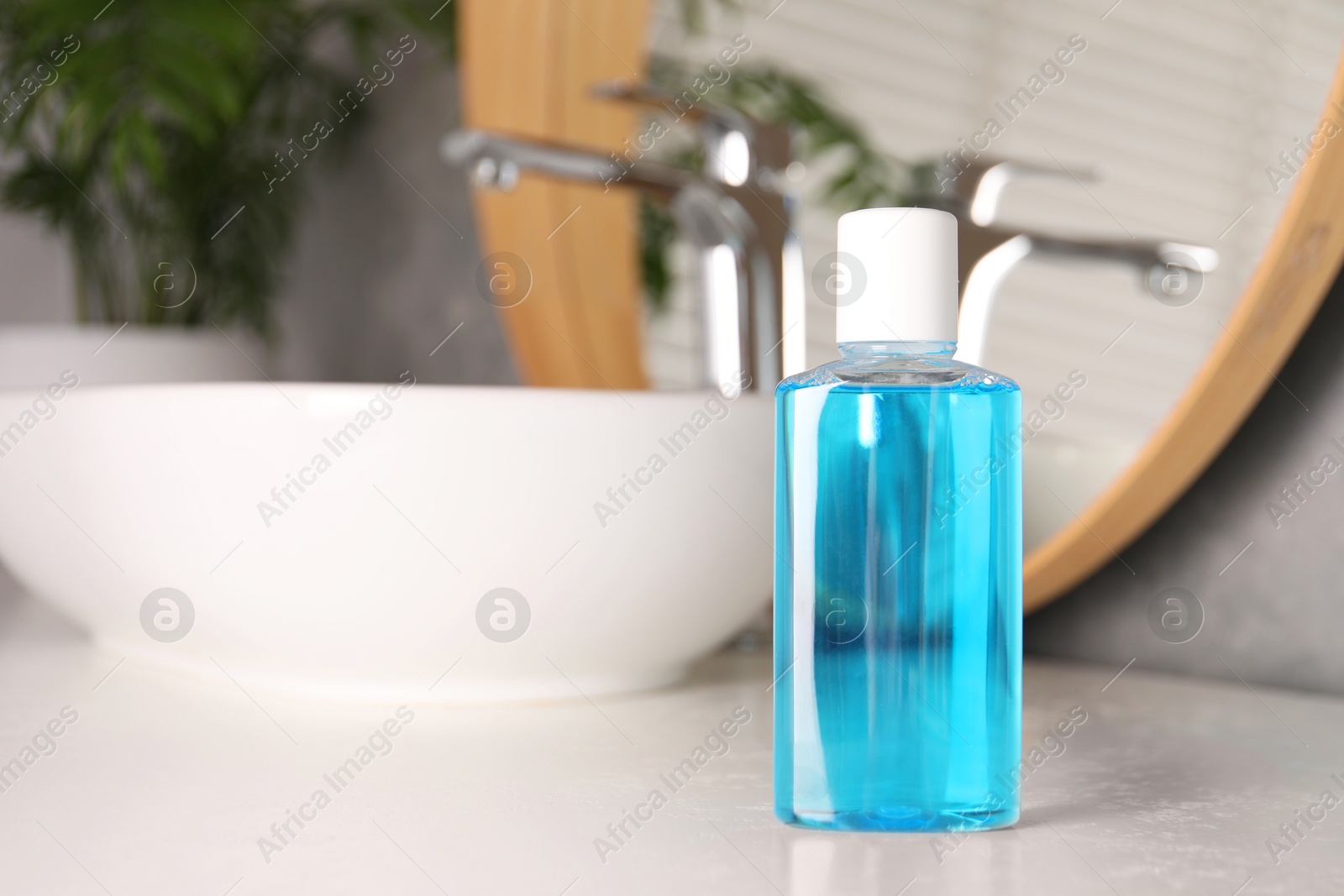 Photo of Bottle of mouthwash on white countertop in bathroom