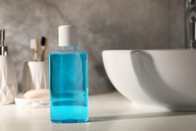 Photo of Bottle of mouthwash on light countertop in bathroom