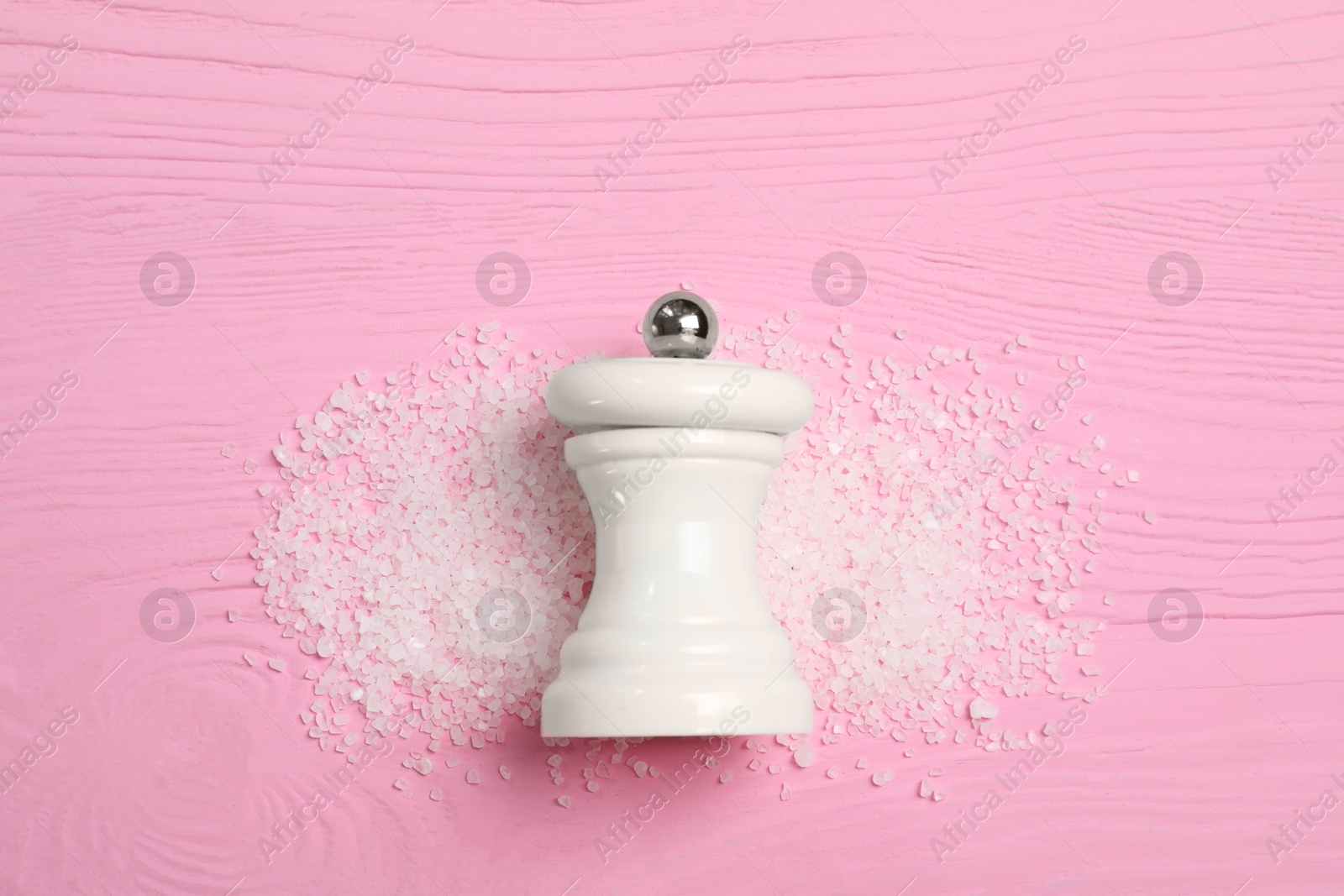 Photo of Salt shaker on pink wooden table, top view